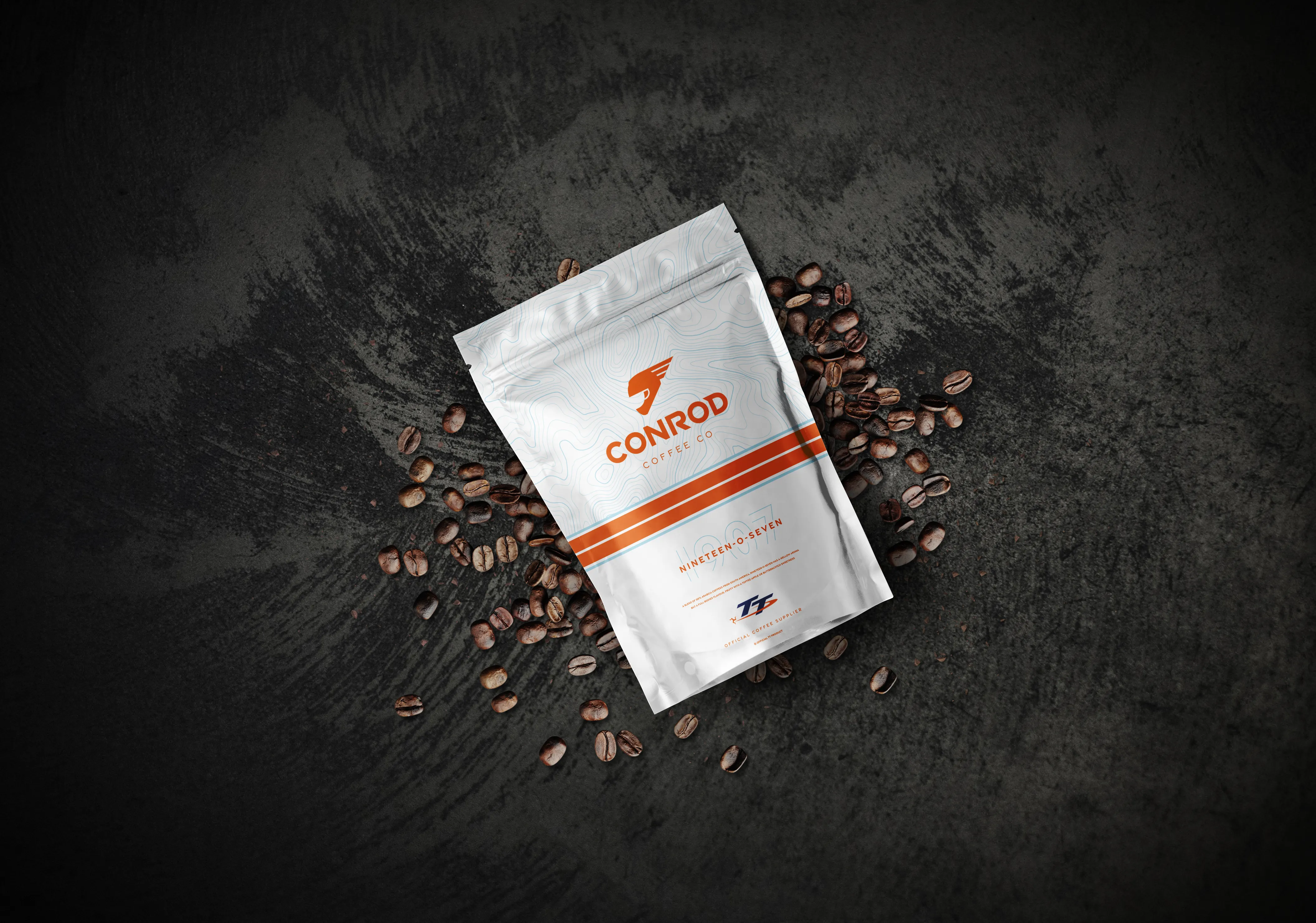Conrod Coffee Co Nineteen-O-Seven blend coffee bag in white surrounded by coffee beans, photographed by DotPerformance for the Conrod Coffee Co website and e-commerce store